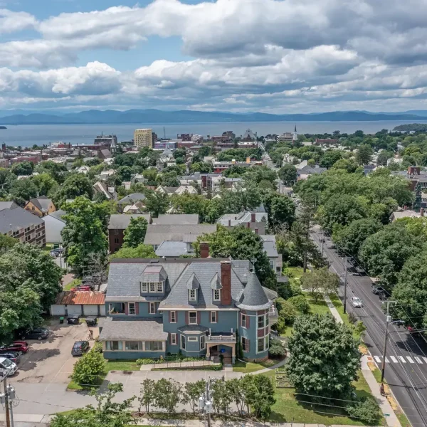 Aerial view of transitional living home surrounded by greenery in a residential neighborhood.