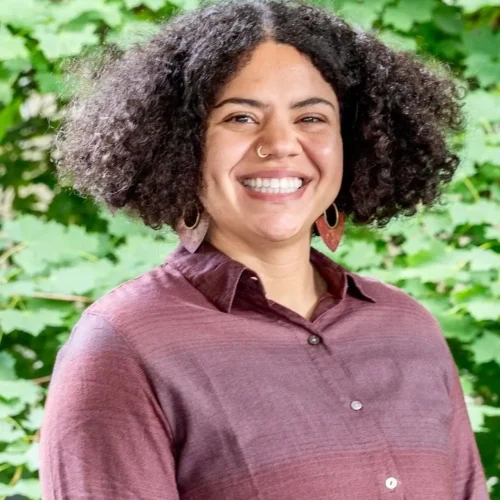 Smiling woman outdoors representing mental health and wellness services.