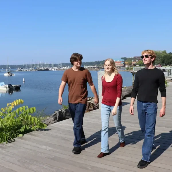 People walking along a waterfront boardwalk for transitional living support.