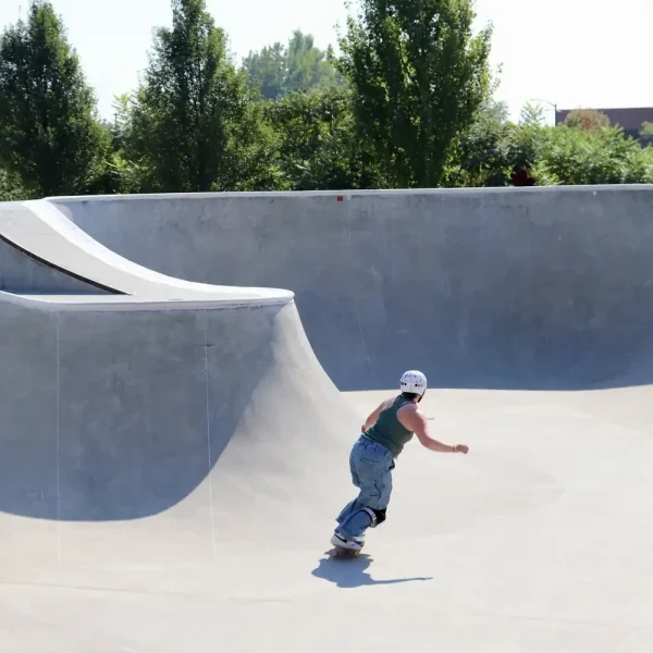 Young person skateboarding in a concrete skatepark during transitional living program.
