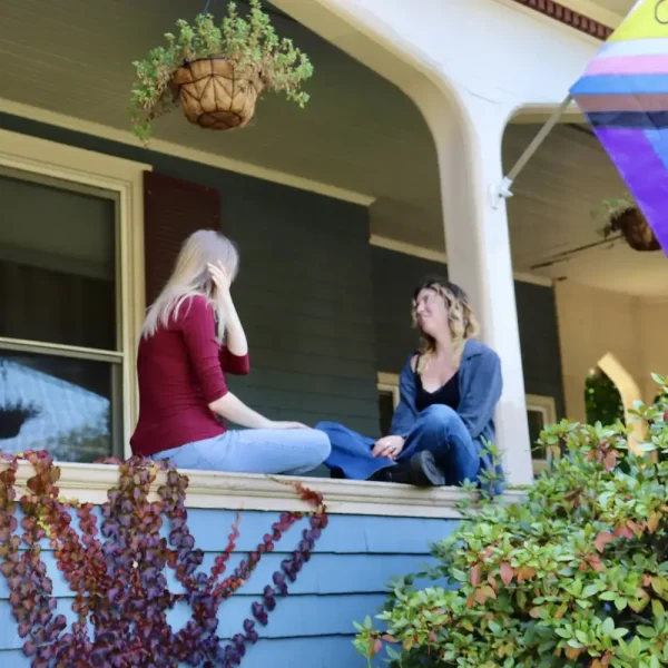 Two women talking on a porch, promoting transitional living services.