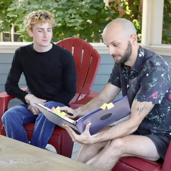 Young adult and counselor engaging in supportive counseling outdoors.